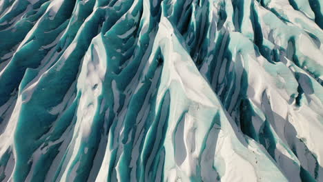 The-beautiful-blueish-white-snow-covered-carvasses-of-Kviarjokull-in-South-Iceland---low-aerial