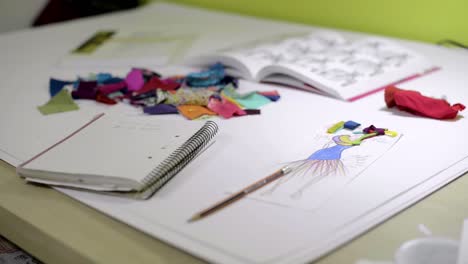 panning of a fashion designer's workstation with drawings and sketches