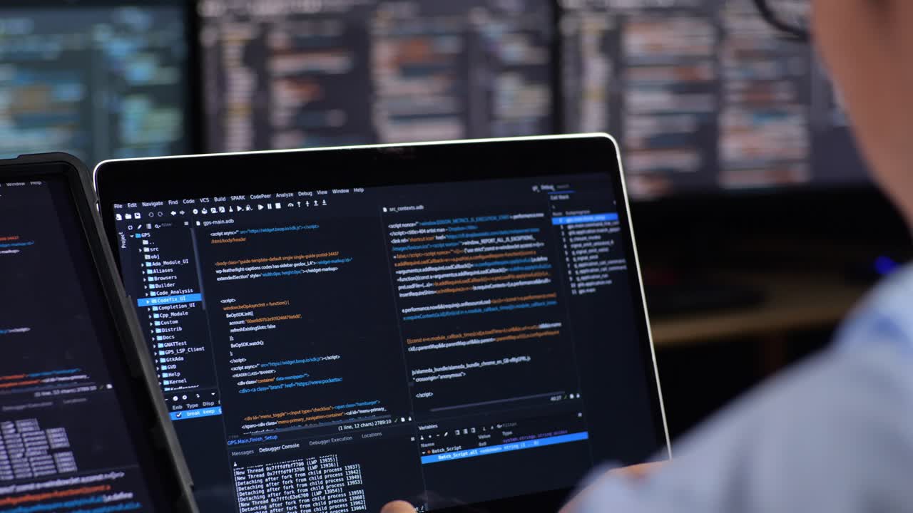 persona codificando por la noche en múltiples pantallas