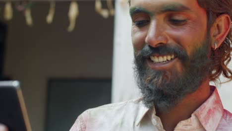 indian man close-up of face smeared with bright holi colors