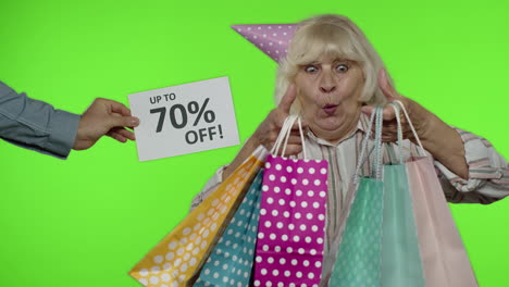 inscription up to 70 percent off appears next to grandmother. woman celebrating with shopping bags