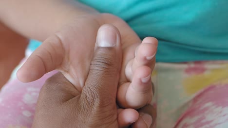 close-up of an adult hand holding a child's hand