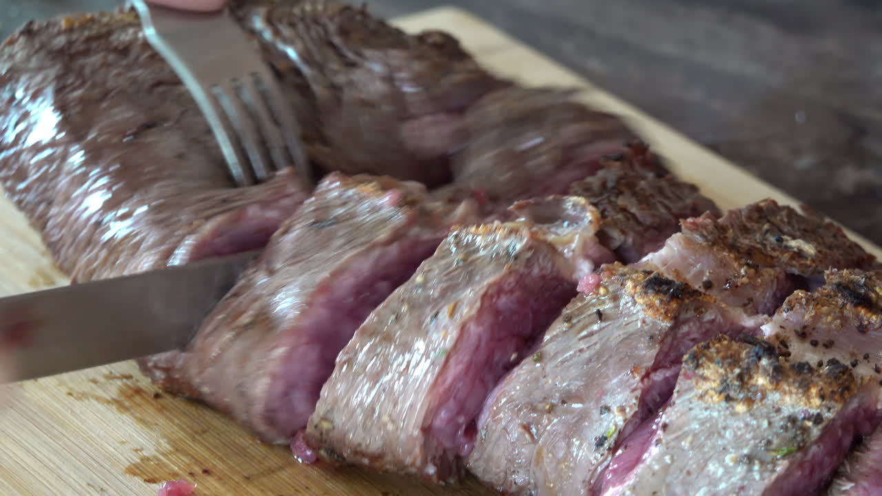Woman cutting up a piece of red meat on a wooden cutting board