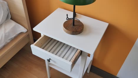 white nightstand with green lamp