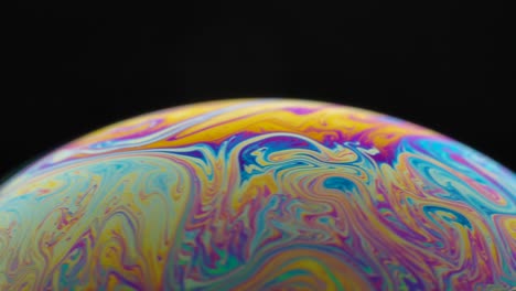 close-up of an iridescent soap bubble with swirling colors