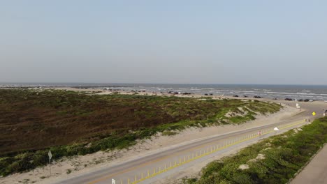 Taking-off-from-parking-lot,-woman-walking-towards-beach