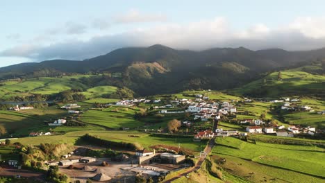 drone footage of sub tropical volcanic island countryside town at sunset with fog mountain in backdrop