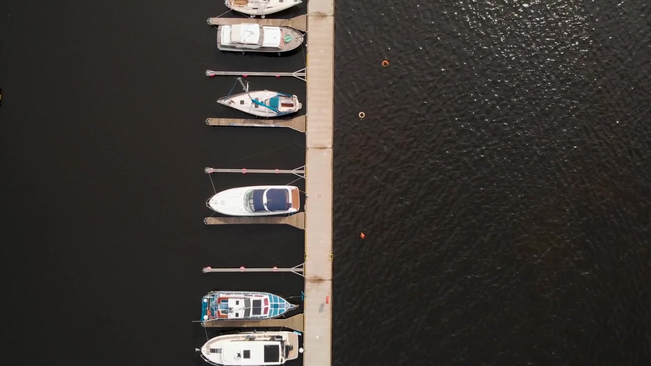 Set ovenfra af sejlbåde og lystbåde fortøjet i lystbådehavnen ved søen i Szczecin, Polen. - luftfoto