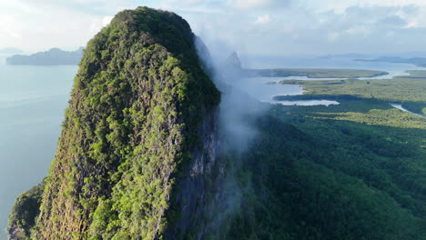wispy clouds over towering limestone karsts in phang nga bay, thailand. aerial drone shot