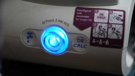 pressing the on and off button of the steam iron