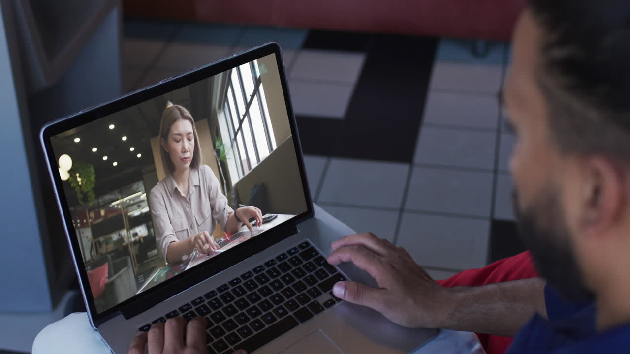 Middle eastern man having a video call with female colleague on laptop