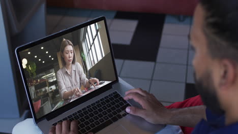 hombre de oriente medio haciendo una videollamada con una colega en una computadora portátil