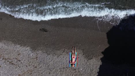 People-at-the-beach-aerial-drone-view-playing-beach-tennis,-sunbathing,-enjoy-holidays-at-the-seashore