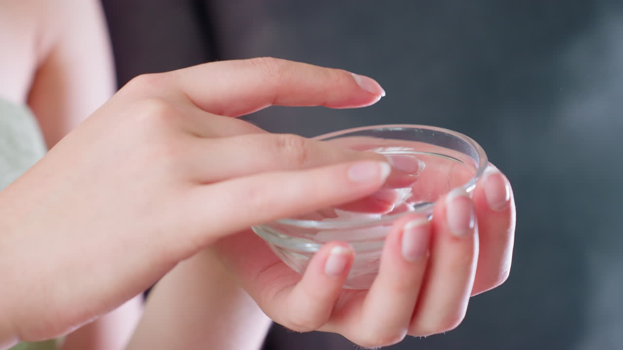 Hand view mixing cream in container, preparing to apply, beauty routine, facial care, skincare treatment, moisturizing, self-care, hydration, skincare products, skin nourishment