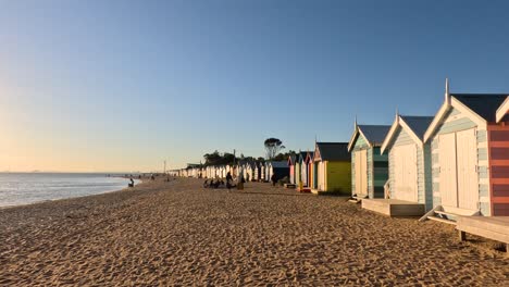 cabañas de playa coloridas con un sol poniente