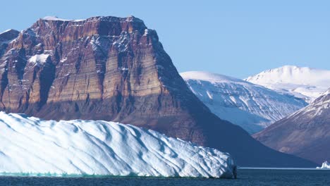 stunning landscape of greenland, iceberg, limestone cliffs, snow capped peaks and glaciers on sunny day