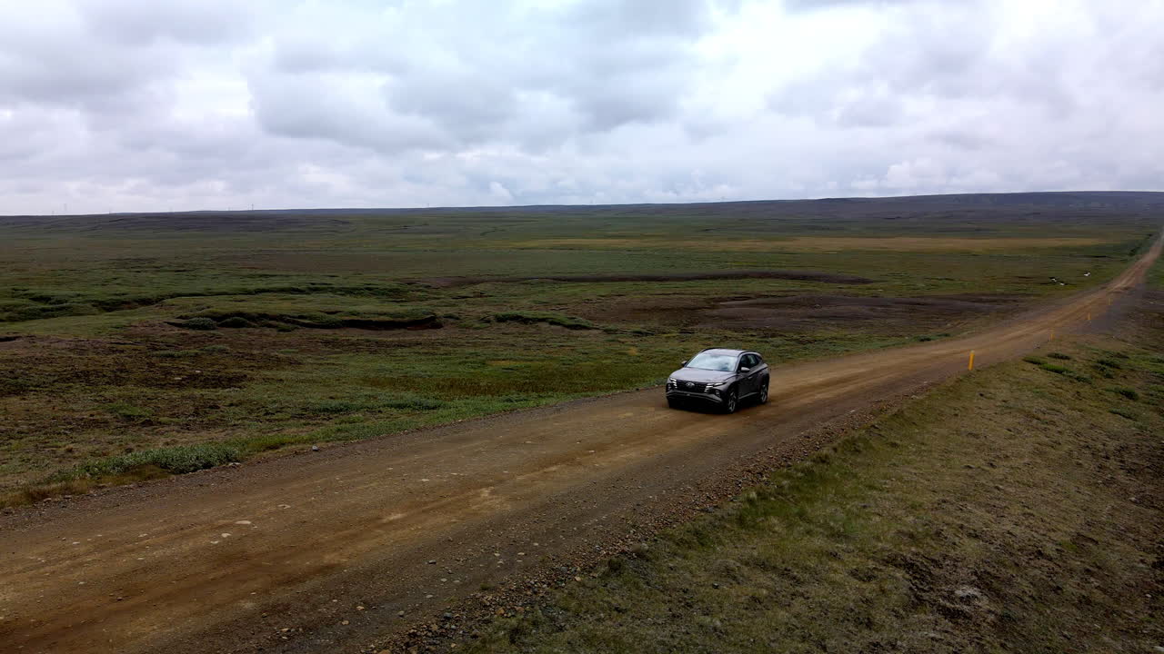 아이슬란드의 외로운 자갈길을 지나가는 자동차의 공중 원형 샷
