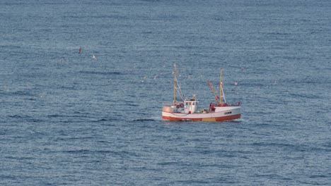pequeño barco de pesca blanco navegando en un mar abierto del norte de noruega, cámara lenta de 60 fps