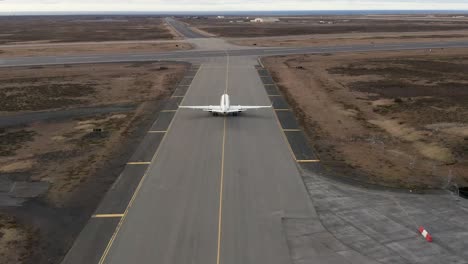 back view of private jet taxiing on flight line towards airstrip for take off