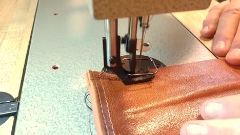 clip of a man sewing a piece of leather with an industrial walking foot sewing machine