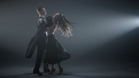 elegant ballroom couple dancing on stage. professional dancers performing waltz.