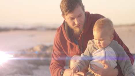 animation of light spots over caucasian father holding child at beach