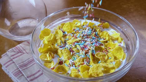 flocos de maíz amarillos crujientes en el cuenco para la mañana un delicioso desayuno con leche. cámara lenta con toma de seguimiento de rotación.