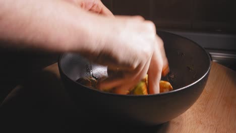 a close up shot of the hand of a chef mixing spices and seasoning to his freshly prepared brussels sprouts, spreading the seasoning is important for an even and consistent flavour