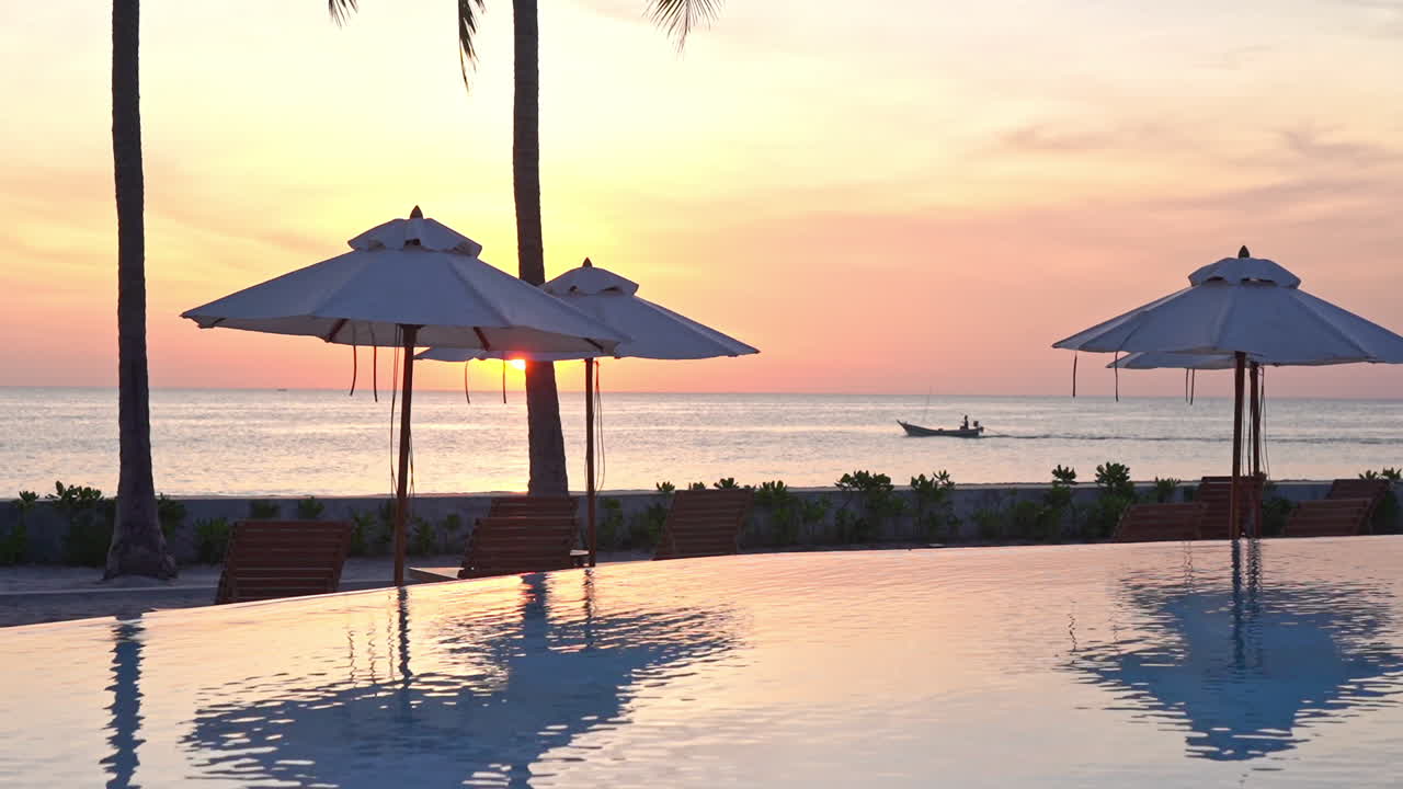 작은 보트가 먼 거리를 지나갈 때 아름다운 구름과 바다 표면에 반사되는 멋진 일몰 하늘과 수영장