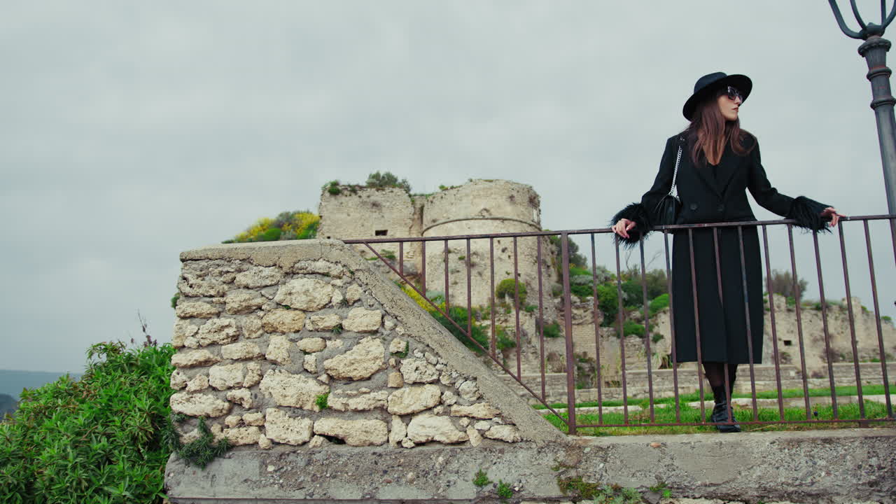 Elegant Model Posing On The Railing In The Medieval Italian Town Square