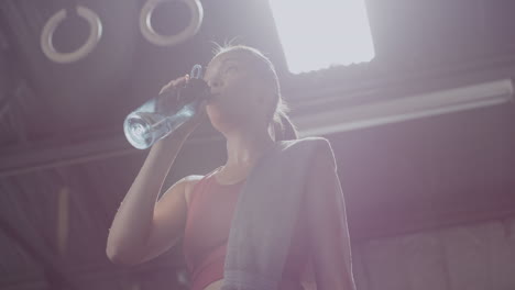 active young woman drinking water during a break