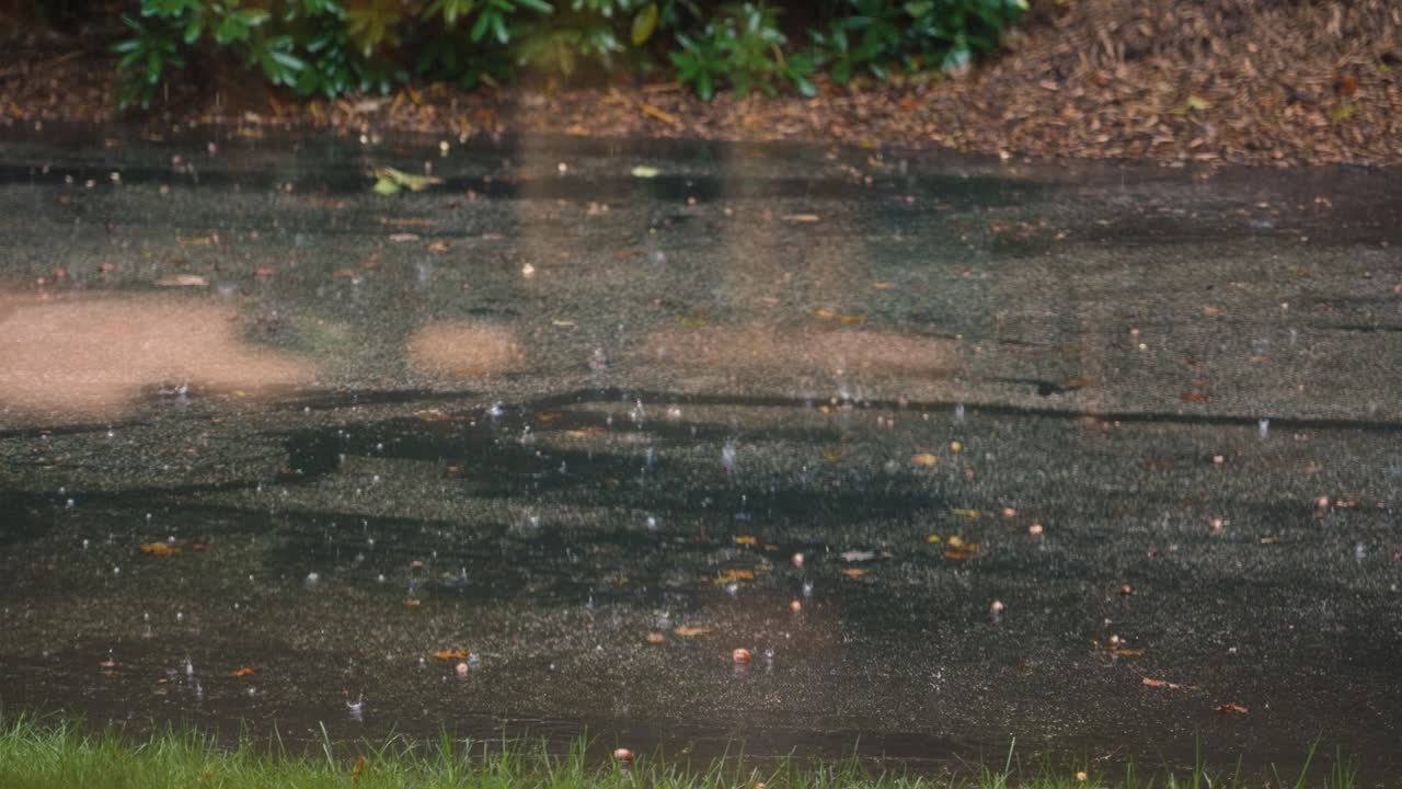 Slow motion look at a downpour through a front window.