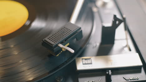 movimiento cinematográfico alrededor de la aguja de un tocadiscos lp, cierre la diapositiva mientras el disco gira lentamente