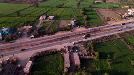 crop fields lands with national highway and vehicles at harnampur, madhya pradesh, india. day time, push in, tilt down, drone shot, 4k.