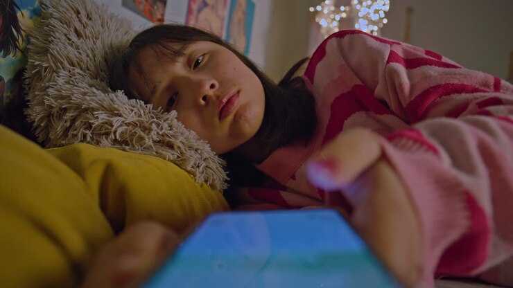 Teenage Girl Using Smartphone in Bed