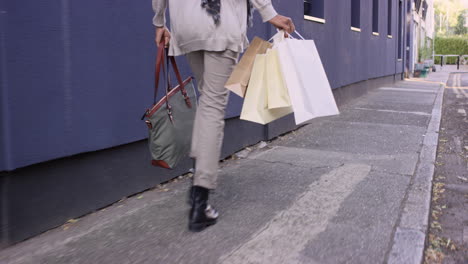 beautiful woman carrying shopping bags walking through city