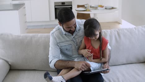 Niña-Alegre-Sentada-En-El-Regazo-De-Su-Padre