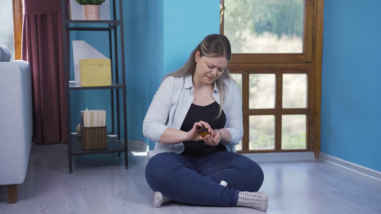 mujer joven suicida apoyada en la pared.