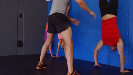 entrenador de fitness que ayuda a las personas a realizar el handstand