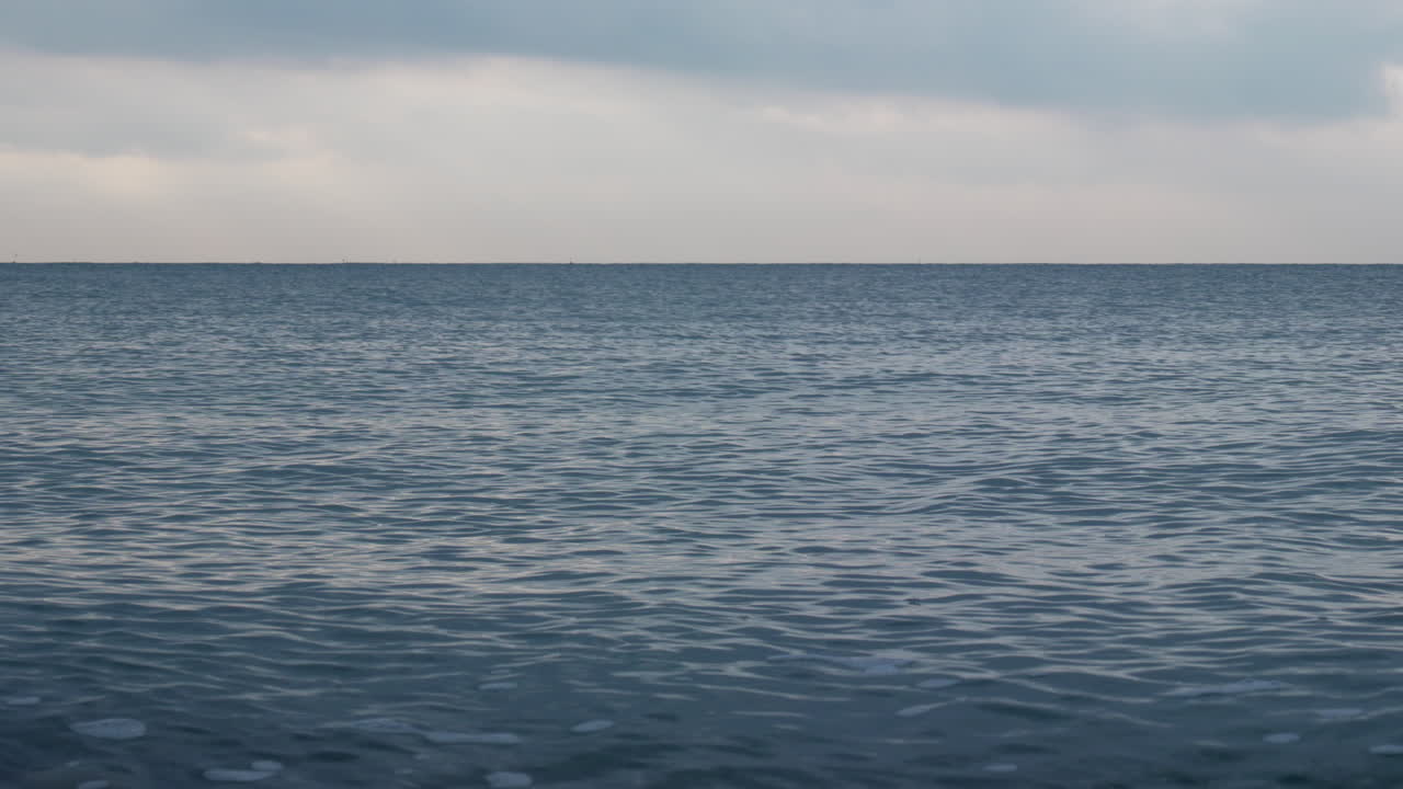바다의 파도 질감은 표면에 반사된 새벽 빛의 부드러운 빛처럼 매혹적인 고요함으로 반짝였습니다.