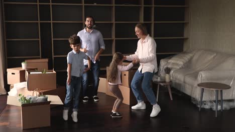 couple and preschool kids celebrate relocation day dance feel happy