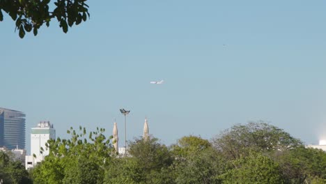 avión que volaba sobre la mezquita y el horizonte de la ciudad en dubai, emiratos árabes unidos en un día soleado