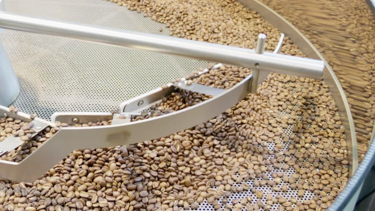 Explore the intricate process of coffee bean roasting in an industrial setting highlighting craftsmanship and quality.