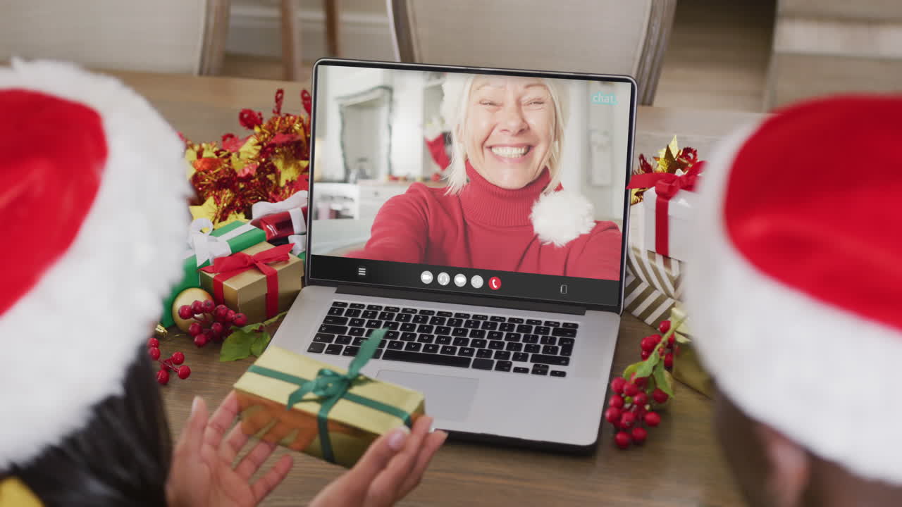 una pareja diversa tiene una llamada de video de navidad con una mujer caucásica mayor.