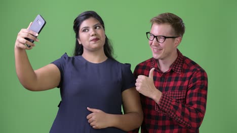 joven pareja de negocios multiétnica juntos contra un fondo verde