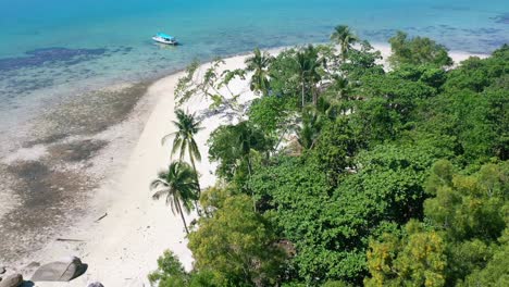 aerial of empty white sand beach and boat anchored on tropical island in belitung indonesia