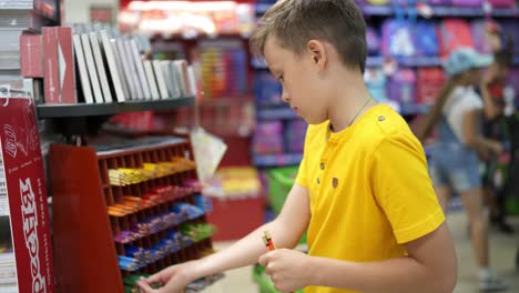 cute boy in stationery store. purchase of school supplies in stationery store