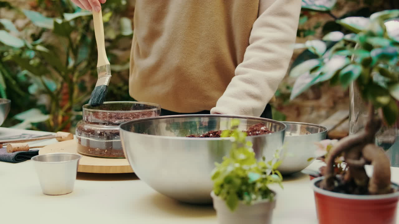 Close-up of Person's Hands Cleaning a Terrarium While Gardening