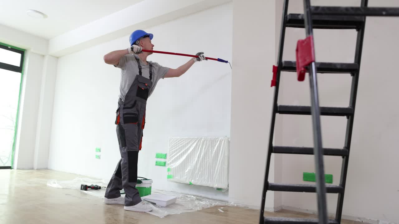 Man painting a wall in a room during home renovation