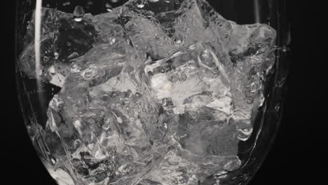 cubos de hielo cayendo de vidrio de primer plano en cámara súper lenta. concepto de extinguidor de sed